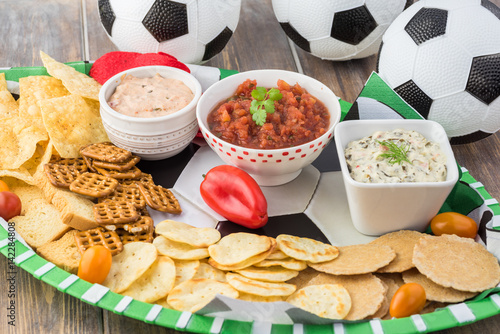 Party table for soccer game with variety of snacks and dips.