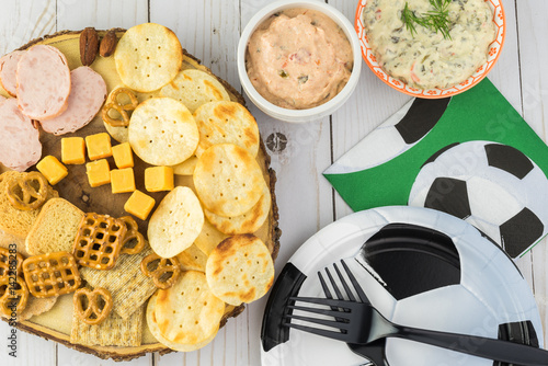 Party table for soccer game with variety of snacks and dips.