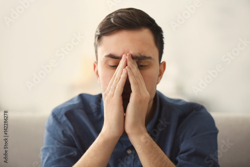 Wallpaper Mural Handsome depressed man on couch at home Torontodigital.ca