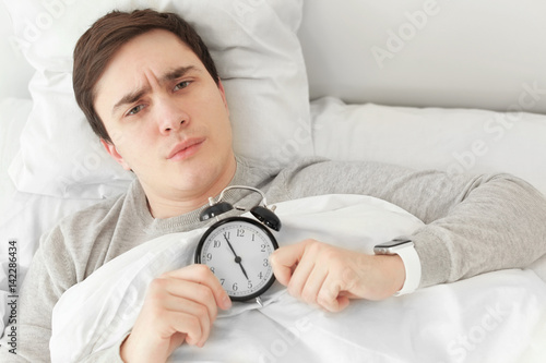 Young man with alarm clock ...