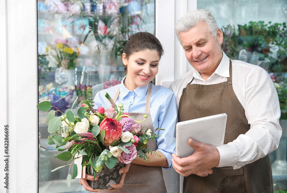 Male and female florists in flower shop Male and female florists in flower shop