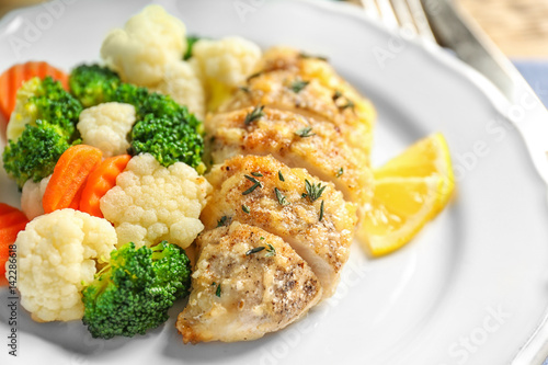 Tasty chicken breast with vegetables on plate, closeup
