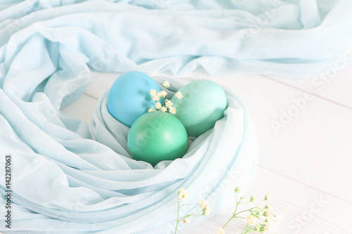 Colorful easter eggs on a white wooden background. Space for text. Top view