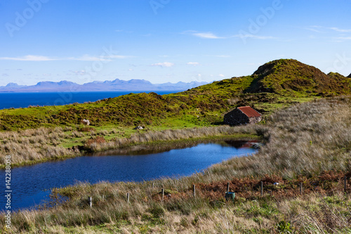 Looking over a small loch and over Staffin Bay at Flodigarry, Trotternish, Isle of Skye, Scotland, UK. photo