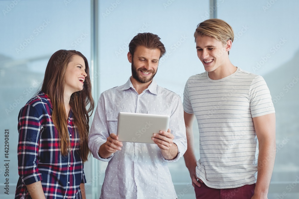 Business executives discussing over digital tablet Business executives discussing over digital tablet