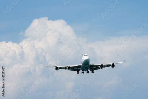 Heavy aircraft fly in front of rain cloud