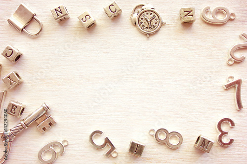 Frame from metal numbers and letters on wooden table with copy space