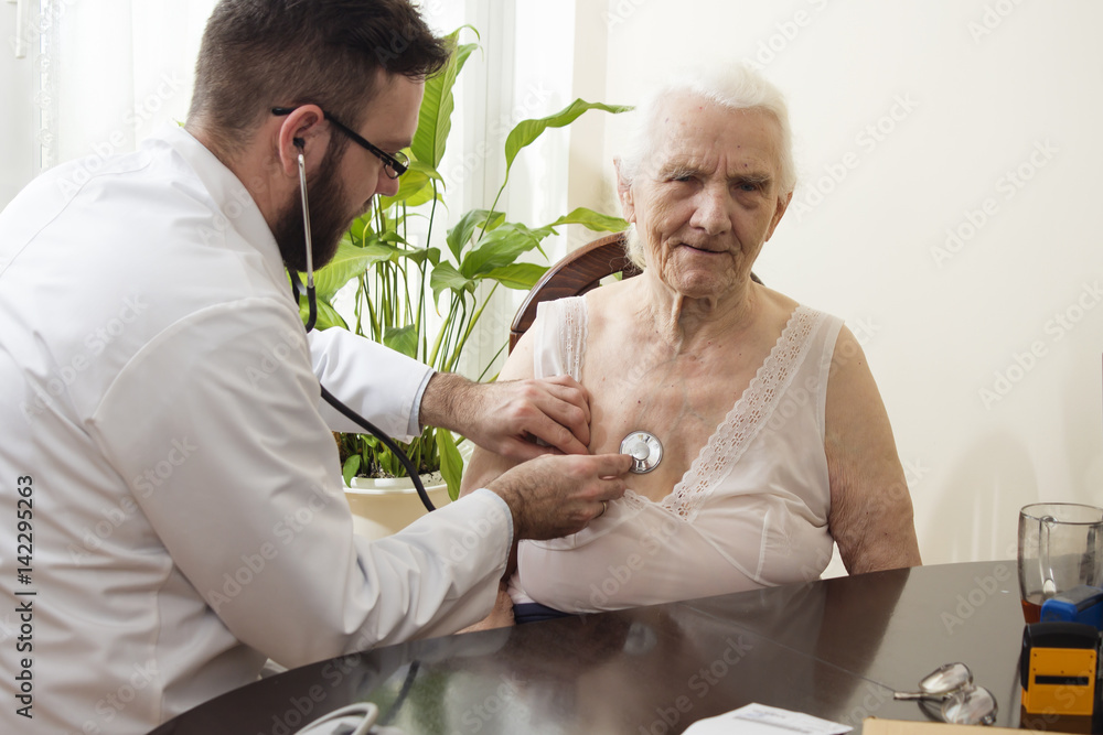 Lekarz bada stetoskopem starą kobietę w gabinecie lekarskim. Badanie  lekarskie stetoskopem. Lekarz geriatra bada płuca. Stock Photo | Adobe Stock