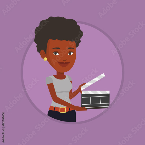 Smiling woman holding an open clapperboard.