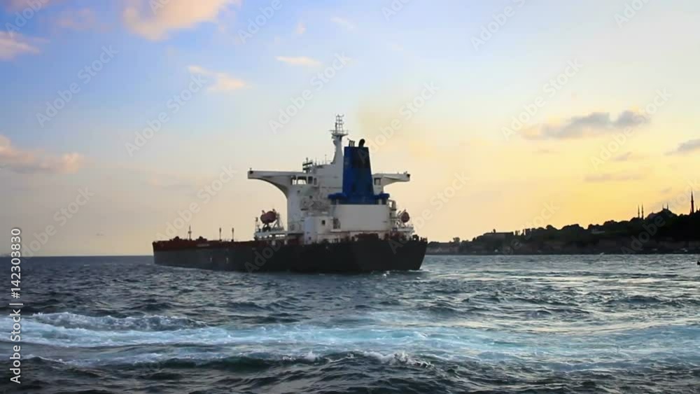 Cargo ship cruising into open sea at sunset. Bulk carrier ship sailing from Black Sea into Marmara Sea Cargo ship cruising into open sea at sunset. Bulk carrier ship sailing from Black Sea into Marmara Sea