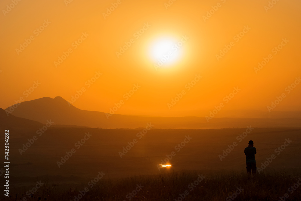 Fototapeta premium Sunset in the mountains, silhouette of man, summer warmth