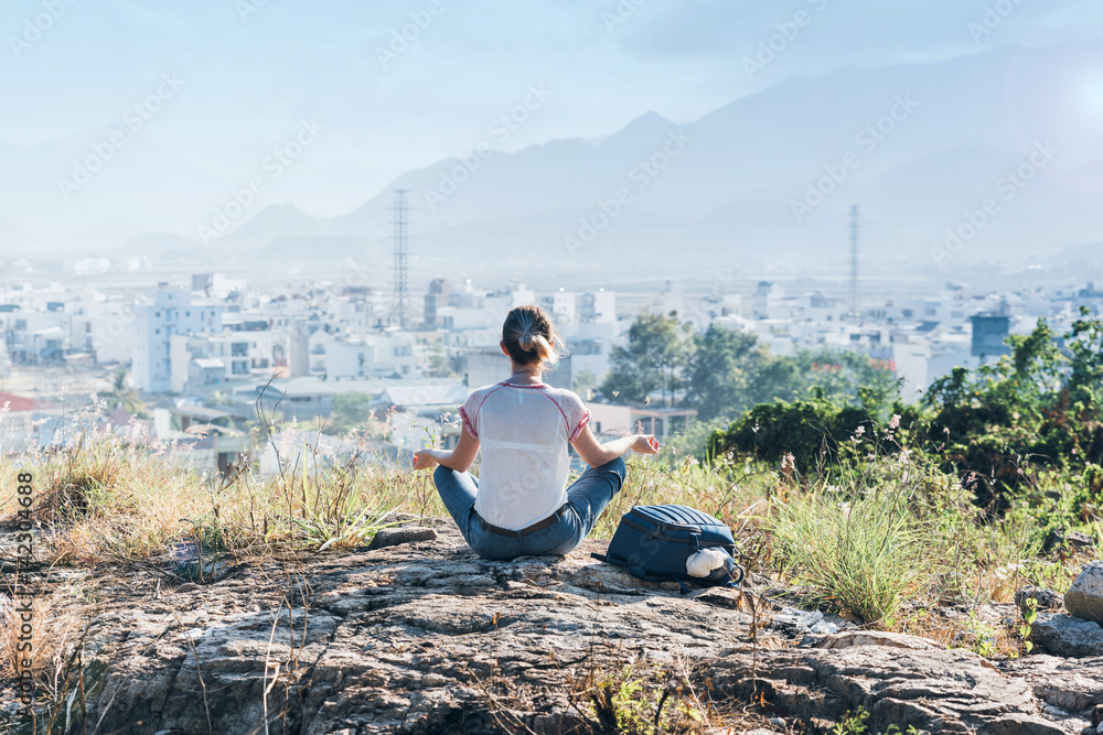 woman on top of the hill meditating