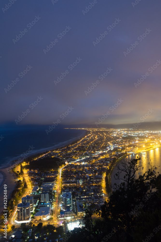 Mount Maunganui township lit by night lights from top of Mount Maunganui.