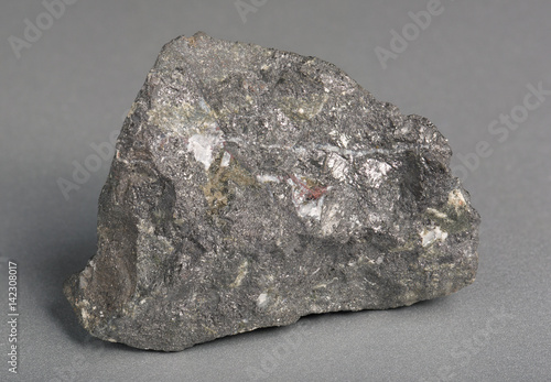 Mineral stone magnetite (lodestone)on gray background.  Magnetite is the most magnetic of all minerals on Earth.  photo
