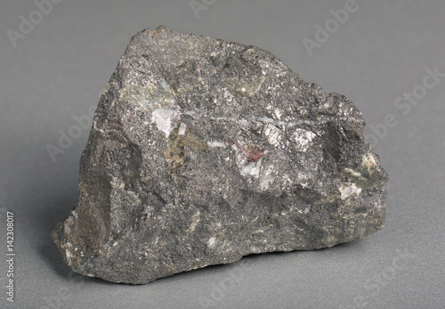 Mineral stone magnetite (lodestone)on gray background.  Magnetite is the most magnetic of all minerals on Earth. 