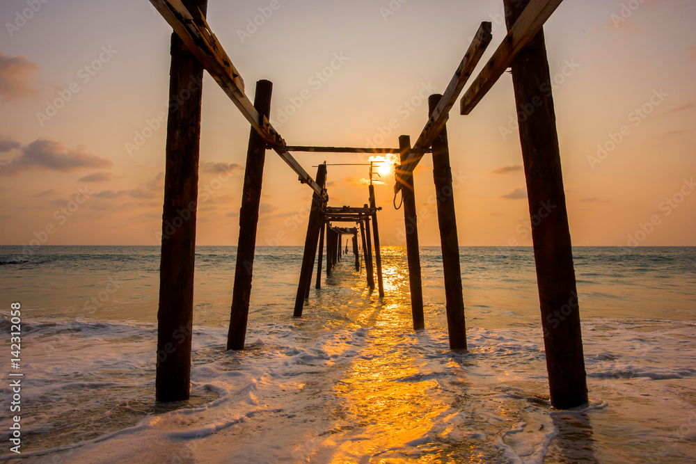 Old wooden bridge on the beach at sunset, Thailand