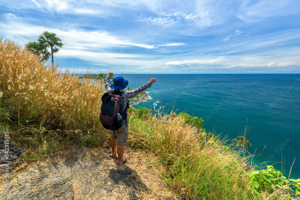 Man with hiking equipment walking at Phromthep cape viewpoint in Phuket,.Thailand - success concept.