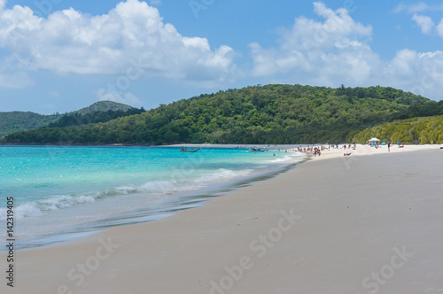 Tropical island beach with people in the distance. Summer background