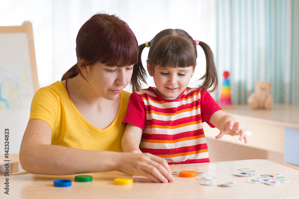 kid girl and mother playing together with puzzle toy kid girl and mother playing together with puzzle toy
