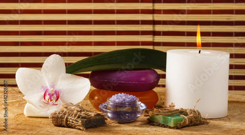 Orchid flower  candle  handmade soap and sea salt for spa procedures on wooden background