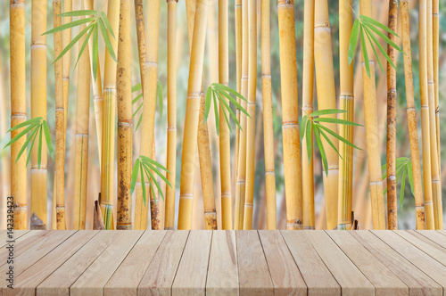 Empty wooden table with yellow bamboo tree background