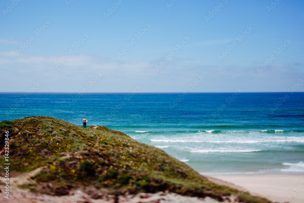 Mann mit Surfbrett an der Küste Portugals, Peniche, Baleal