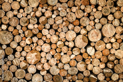 Pile or stack of natural fire wood logs texture background. Abstract photo of natural wooden logs texture.