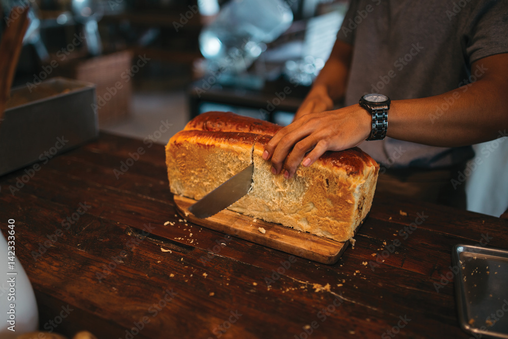 The cook chops the bread on the wooden table The cook chops the bread on the wooden table