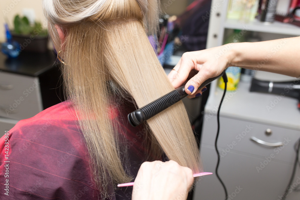 Fototapeta premium Stylist puts women's hair on a plate
