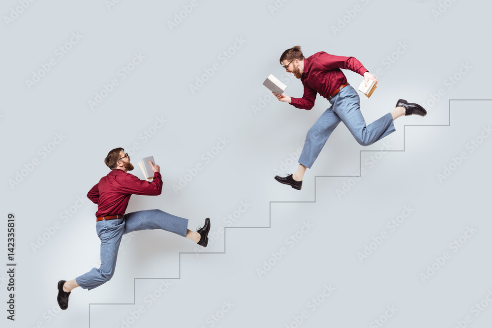 Two funny twin men with books running up and down