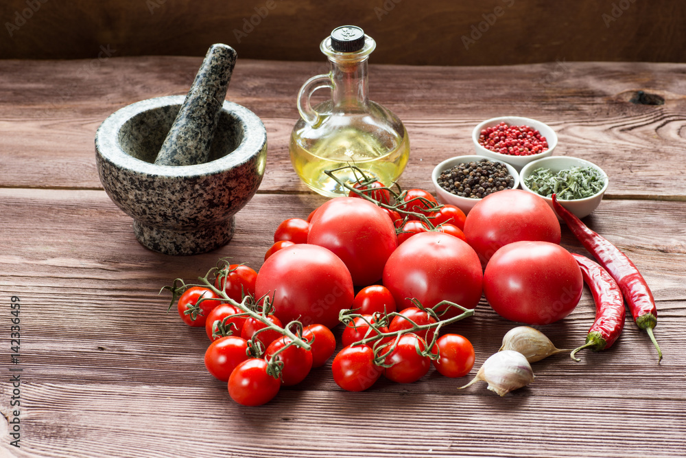 Still Life View of Herbs, oil and Assortment of Raw tomato on Rustic Wood Table