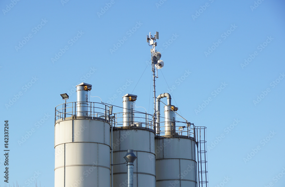 Silver Grain Silos with blue sky in background Silver Grain Silos with blue sky in background