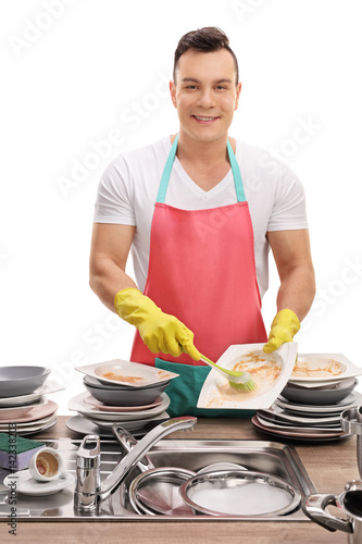 Fotografie Cheerful young man doing the dishes