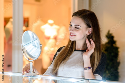 Girl buys earrings at the Mall. photo