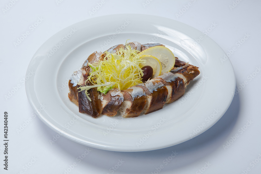 slices of smoked fish mackerel or scomber on a white rectangular dish slices of smoked fish mackerel or scomber on a white rectangular dish