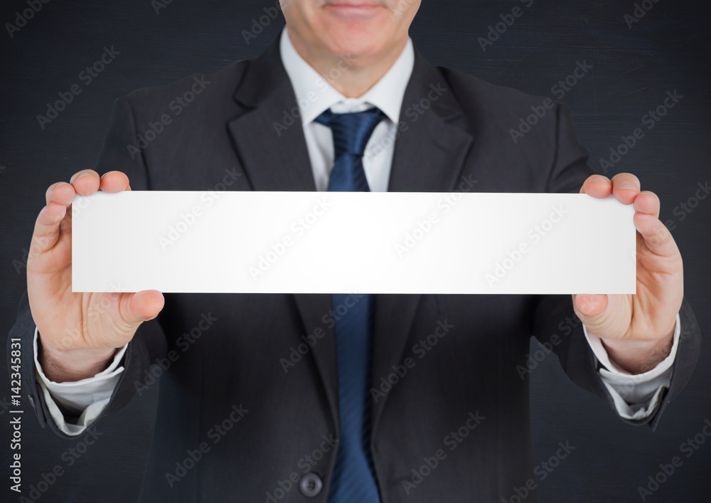 Business man with blank card against navy chalkboard Business man with blank card against navy chalkboard