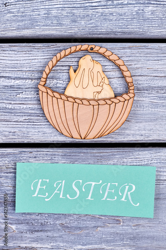 Plywood bunnies in a basket. Easter festive card. Best wishes for spring holiday. photo