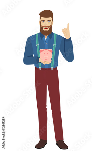 Hipster holding a piggy bank and pointing up