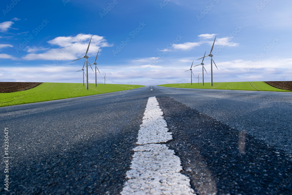 Asphalt road with blue sky and wind turbines