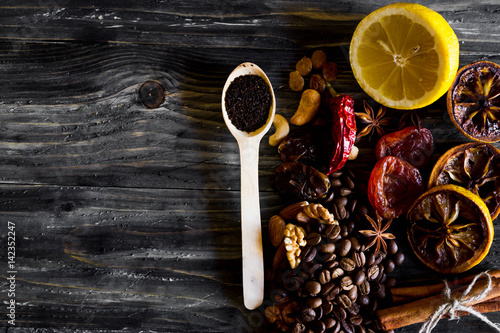 Dried slices of lemon, coffee beans, cinnamon, leaf tea, dried fruits and nuts on a wooden table. Natural product.
