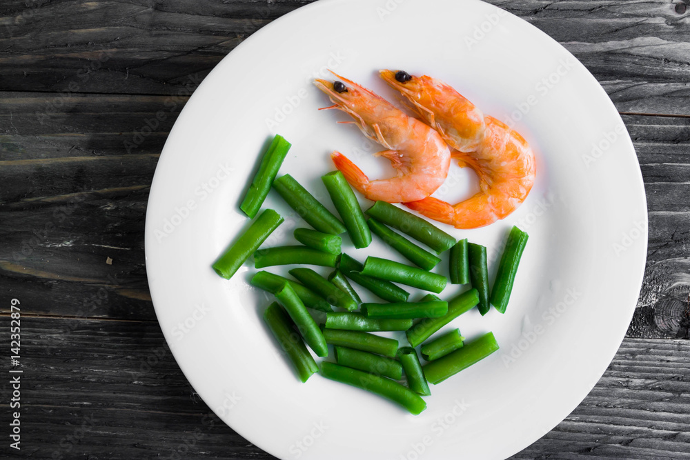 Shrimps with vegetables on a wooden table in rustic style