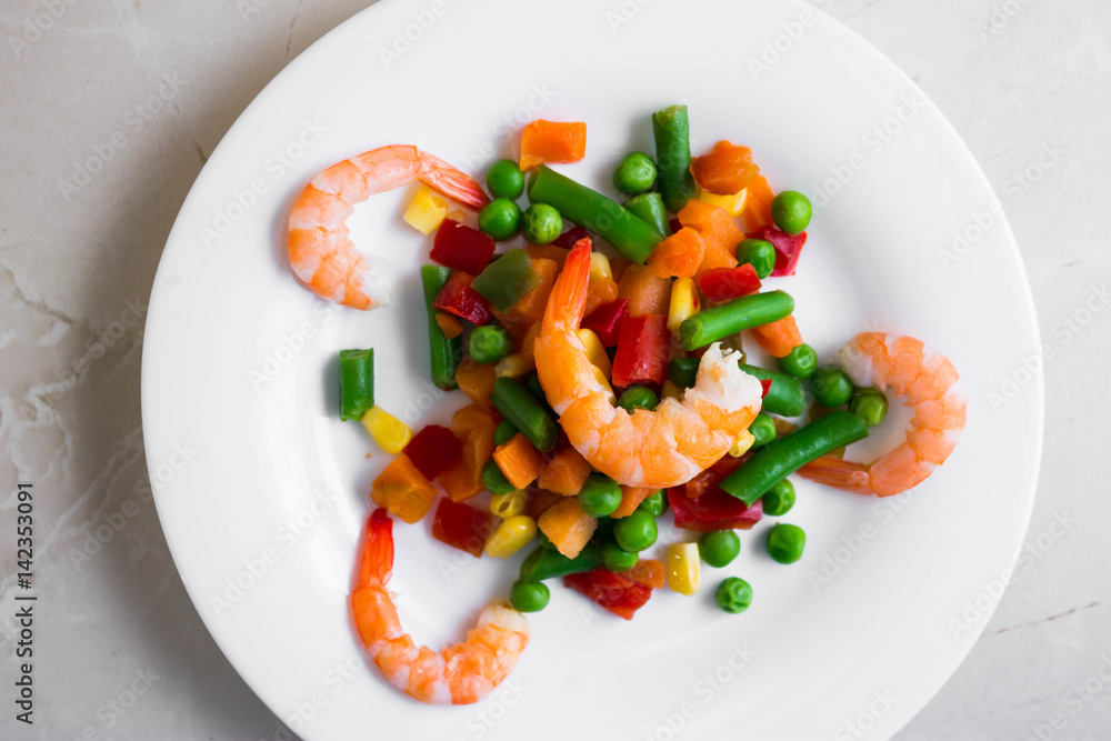 Shrimps with vegetables on a wooden table in rustic style