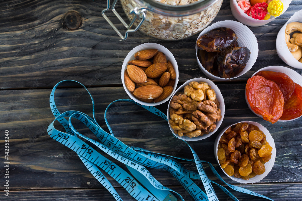 Nuts and dried fruit to the diet on a wooden table in rustic style Nuts and dried fruit to the diet on a wooden table in rustic style