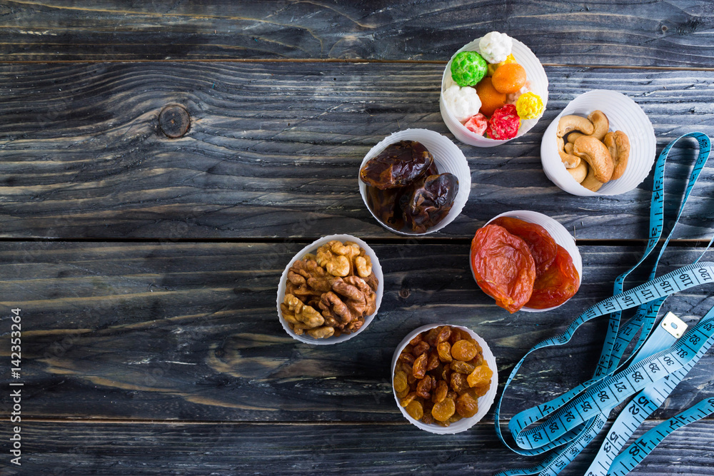 Nuts and dried fruit to the diet on a wooden table in rustic style Nuts and dried fruit to the diet on a wooden table in rustic style