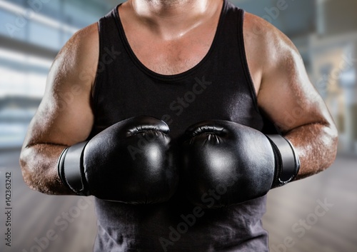 Man with boxing gloves mid sections against blurry gym © vectorfusionart