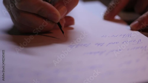 Close-up of a hand, he wrote a letter on paper. The old feather pen.