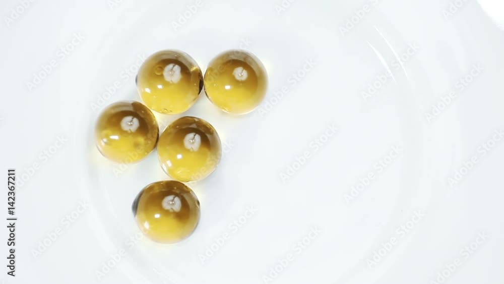 Orange pills poured on white saucer. Orange pills poured on white saucer.