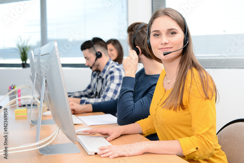 Photos portrait of beautiful and cheerful young woman telephone operator with headset w