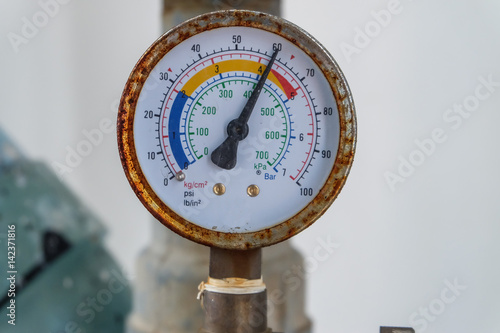 Closeup of manometer, measuring gas pressure. Pipes and valves at industrial plant.