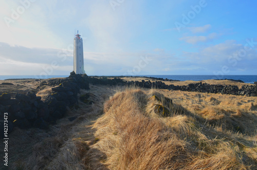 Rugged Coastline and Fields with Malarrif Lighthouse in Iceland photo